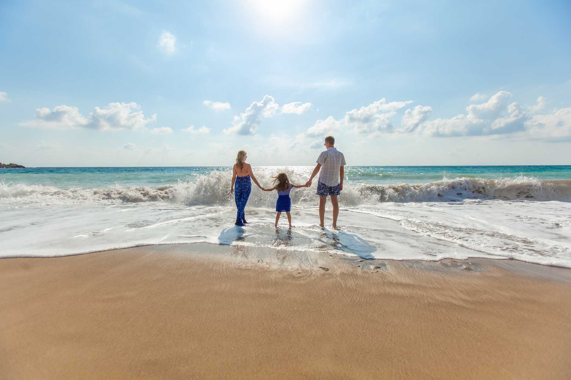 A family standing at the beach on a sunny day